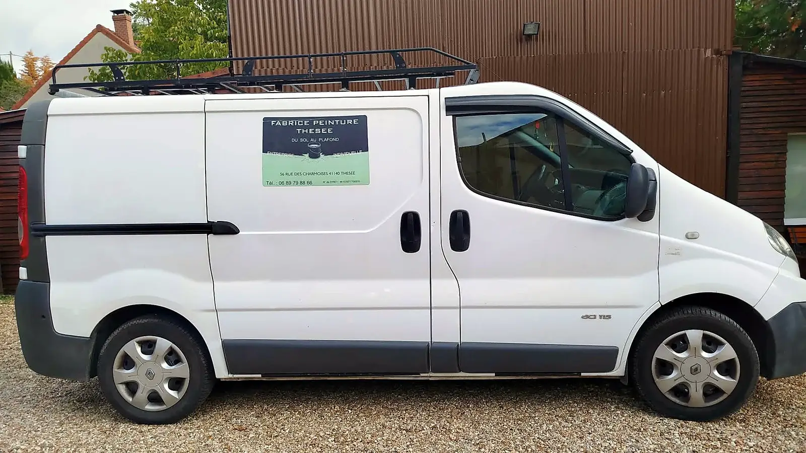 Le camion de Fabrice Peinture Thésée, une camionnette blanche avec un panneau sur la porte coulissante