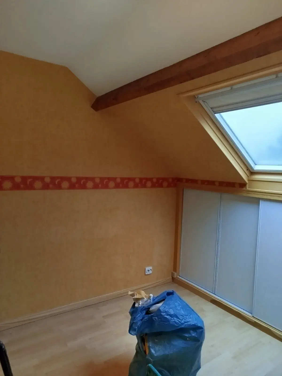 Avant : Chambre mansardée avant travaux, ancien papier peint orangé avec frise