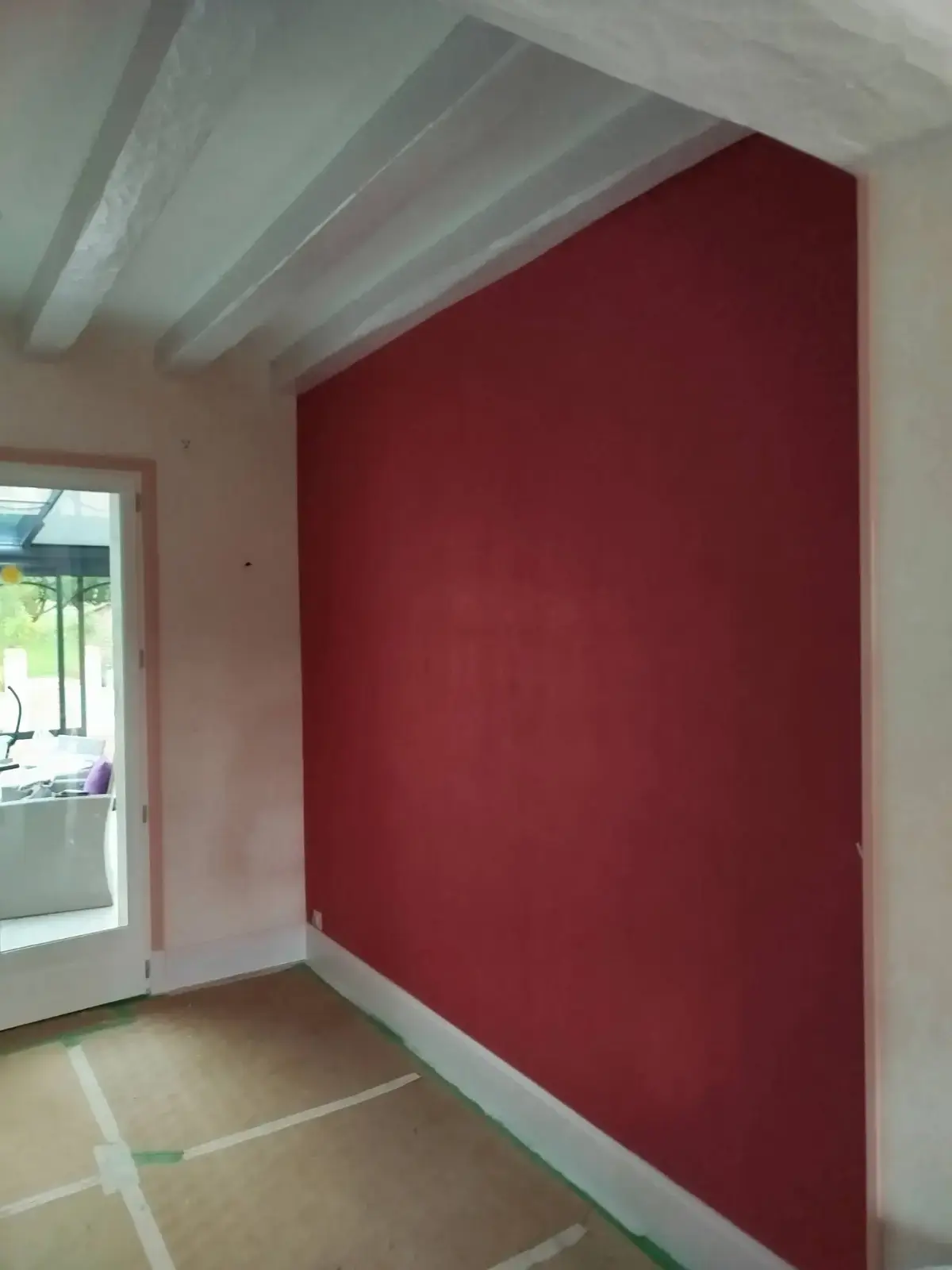 Mur rouge bordeaux sous un plafond à poutres blanches