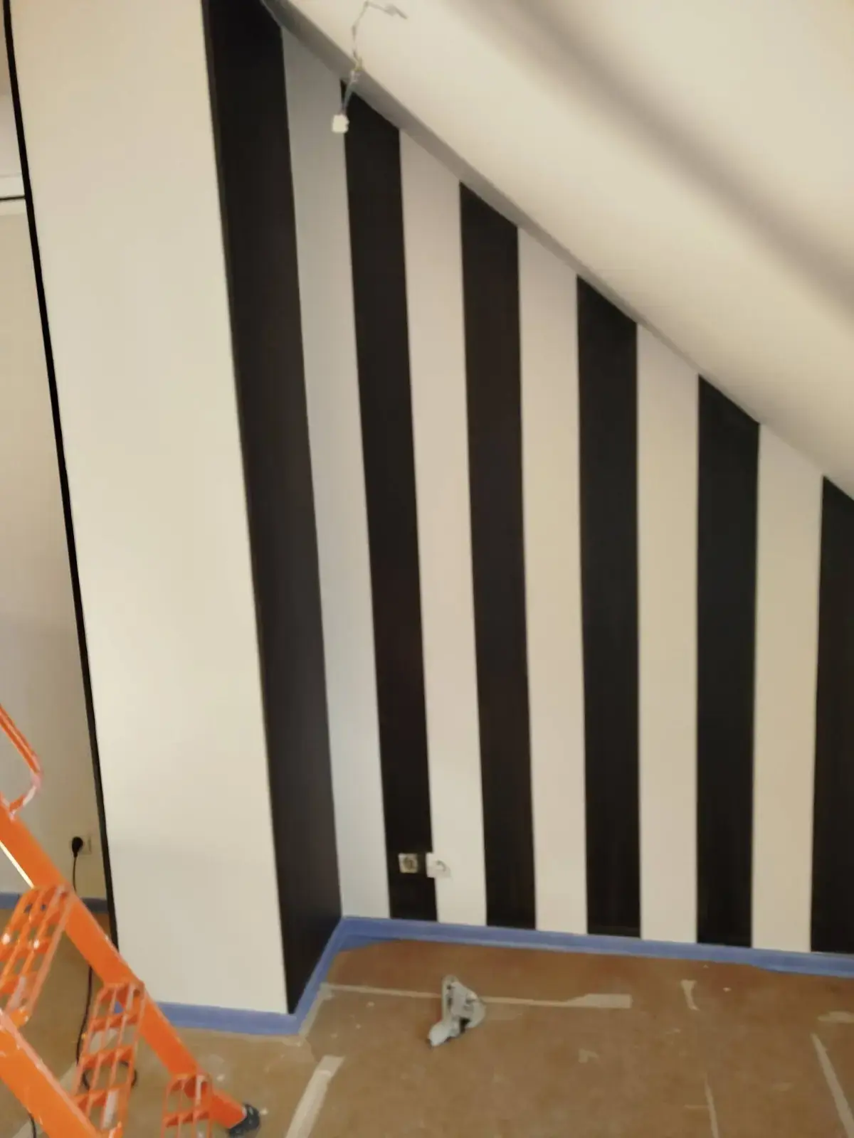 Rayures verticales noires et blanches sous un escalier